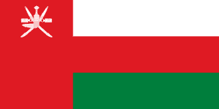 The flag of Oman features a red vertical band on the hoist side that takes up about one-fourth the width of the field, and three equal horizontal bands of white, red and green adjoining the vertical band. At the top of the vertical band is the white emblem of Oman.